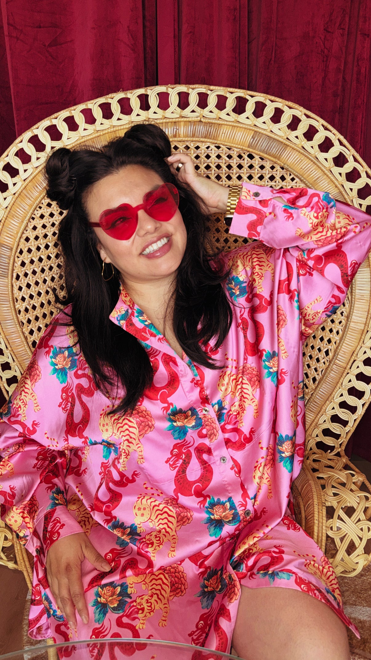 Carla Corazón in a pink dragon-print shirt and red heart sunglasses